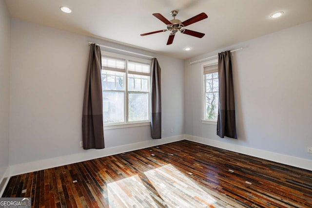 empty room with ceiling fan and dark hardwood / wood-style flooring