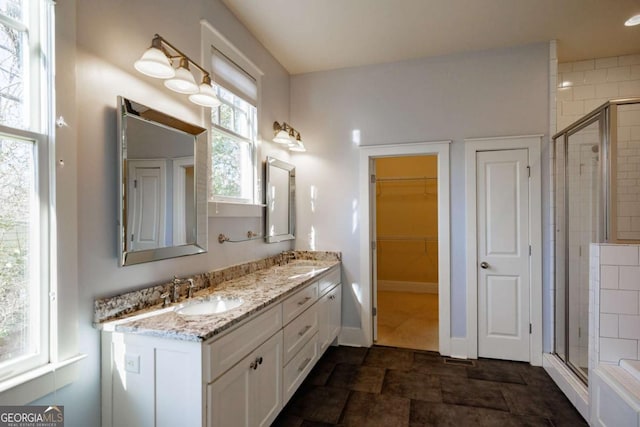 bathroom with a shower with door and vanity