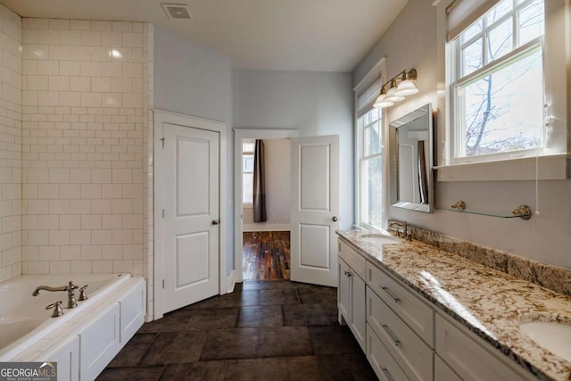 bathroom with vanity and a bath