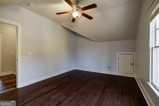 spare room featuring plenty of natural light, dark hardwood / wood-style flooring, and lofted ceiling