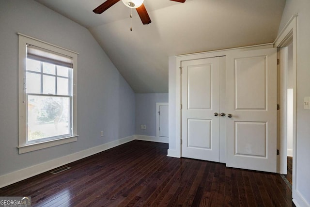 additional living space with a healthy amount of sunlight, dark wood-type flooring, vaulted ceiling, and ceiling fan