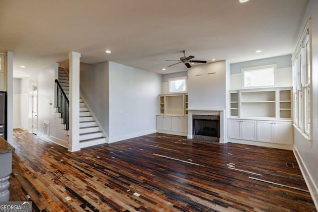 unfurnished living room featuring ceiling fan and dark hardwood / wood-style floors