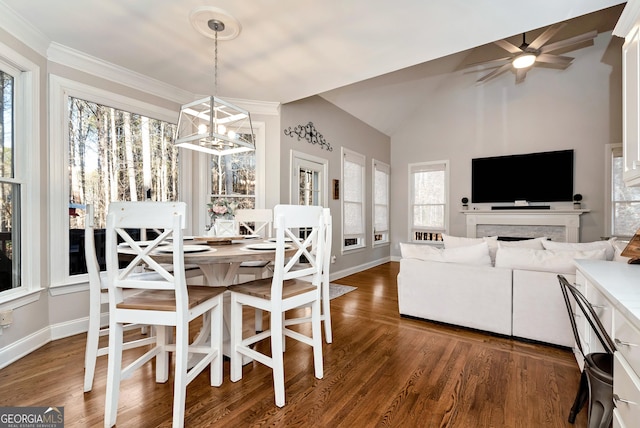 dining space with crown molding, dark wood-type flooring, and ceiling fan with notable chandelier