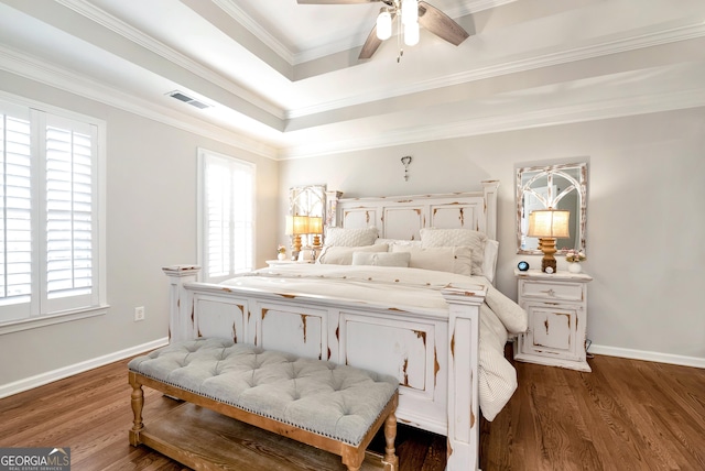 bedroom featuring a tray ceiling, crown molding, wood-type flooring, and ceiling fan