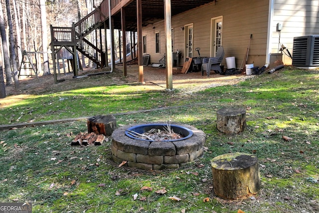 view of yard featuring a fire pit and central air condition unit