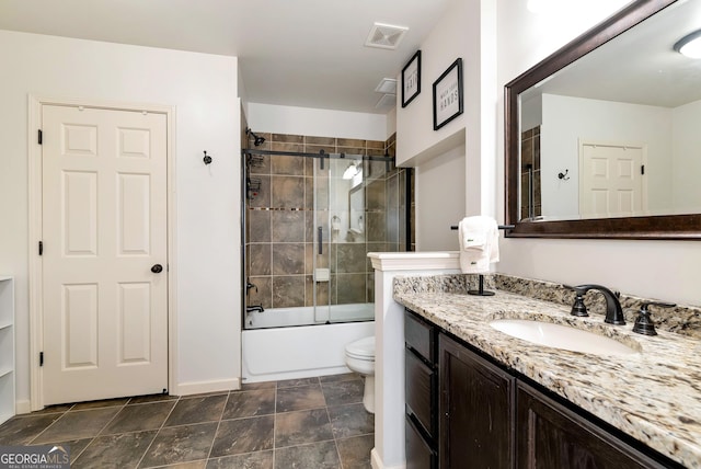 full bathroom with enclosed tub / shower combo, vanity, and toilet