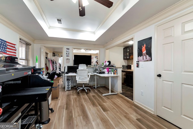 home office with ceiling fan, ornamental molding, a raised ceiling, and hardwood / wood-style floors