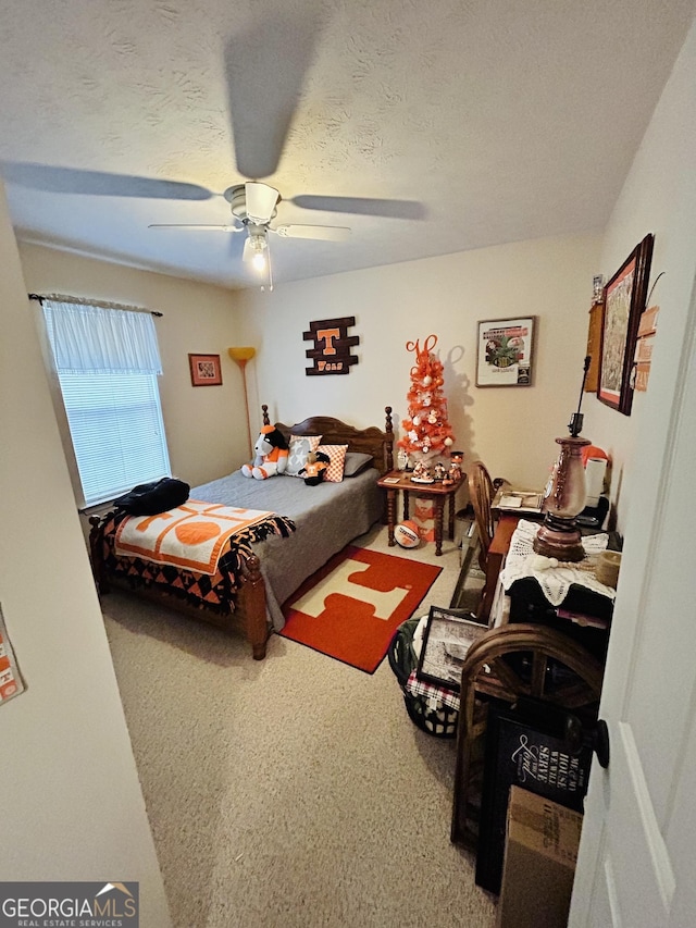 carpeted bedroom with a textured ceiling and ceiling fan