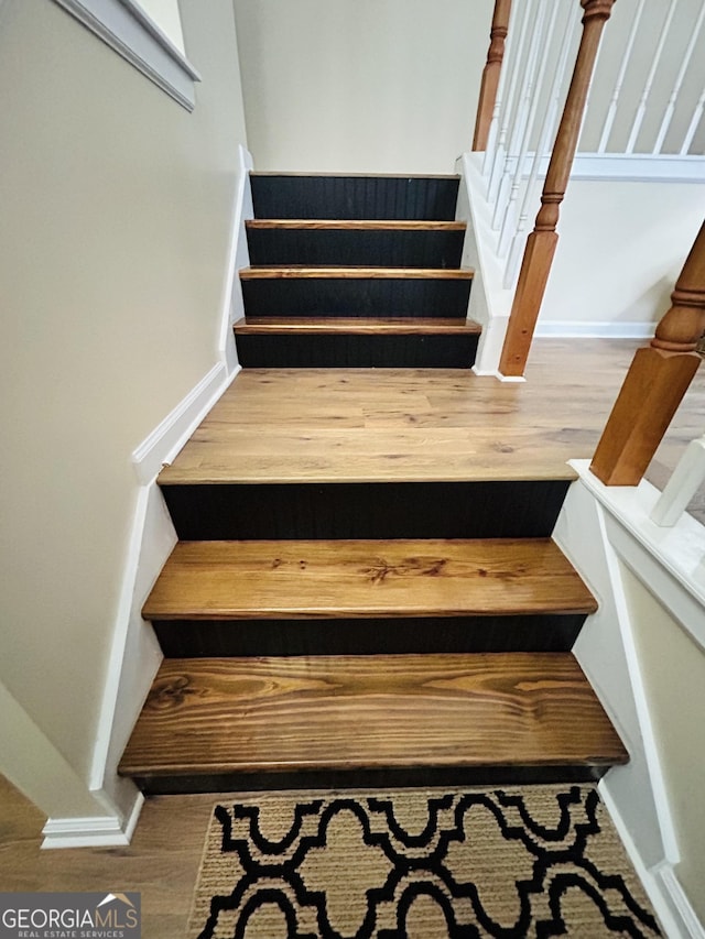 stairway with hardwood / wood-style flooring