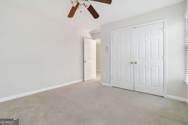 unfurnished bedroom with ceiling fan, a closet, and light carpet