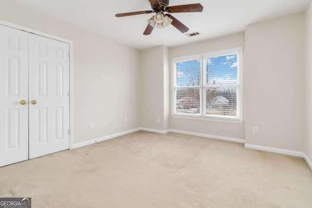 unfurnished bedroom with a closet, ceiling fan, and light carpet