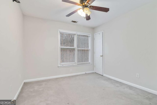 carpeted spare room featuring ceiling fan