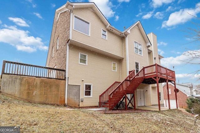 rear view of house featuring a patio, a lawn, and a wooden deck