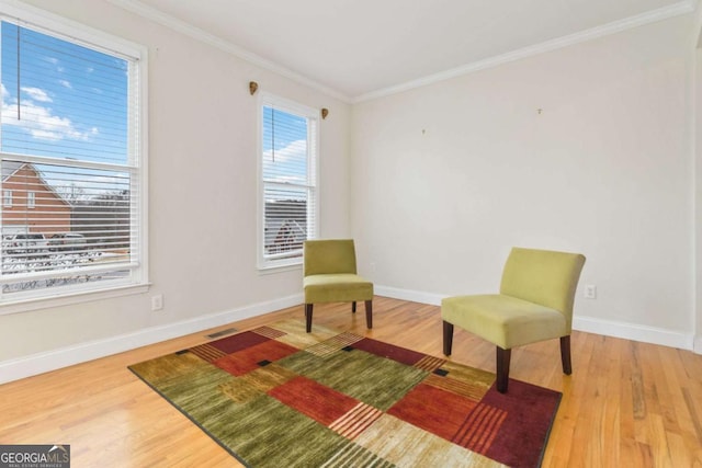 sitting room featuring wood-type flooring and ornamental molding