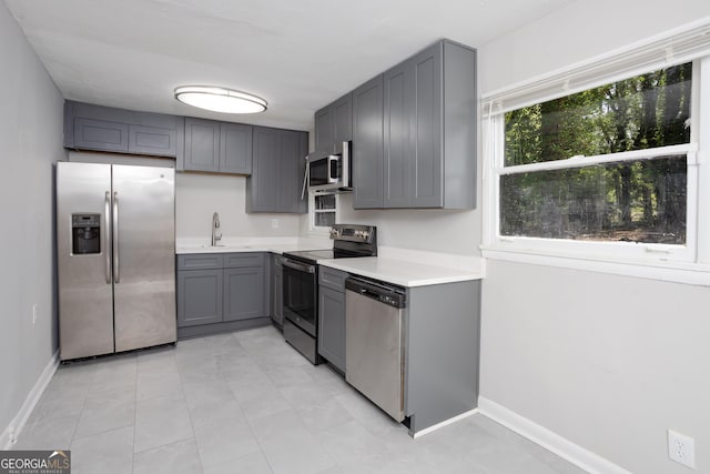 kitchen featuring sink, appliances with stainless steel finishes, and gray cabinets