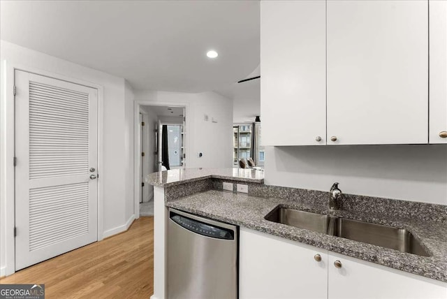 kitchen featuring white cabinetry, dark stone counters, and dishwasher