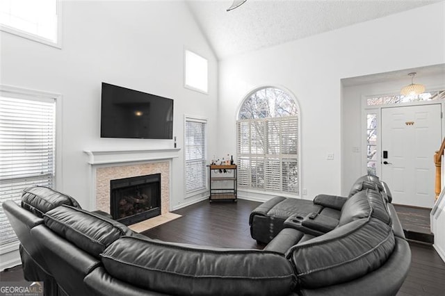 living room with a textured ceiling, dark hardwood / wood-style flooring, and a wealth of natural light