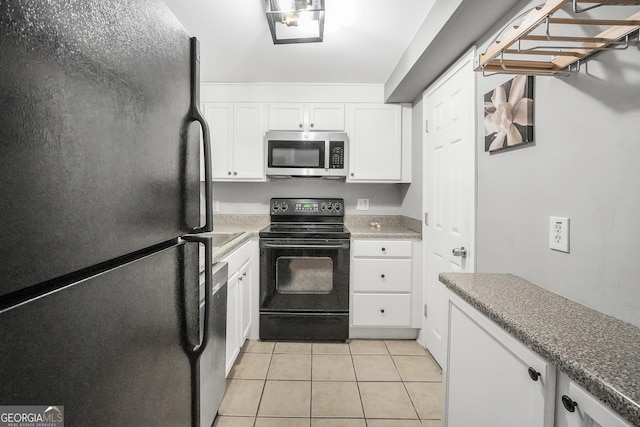 kitchen featuring light tile patterned floors, white cabinets, and black appliances