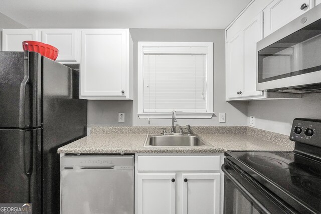 kitchen featuring sink, black appliances, and white cabinetry