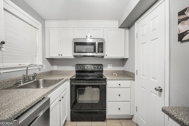 kitchen featuring sink, white cabinetry, appliances with stainless steel finishes, and light tile patterned flooring