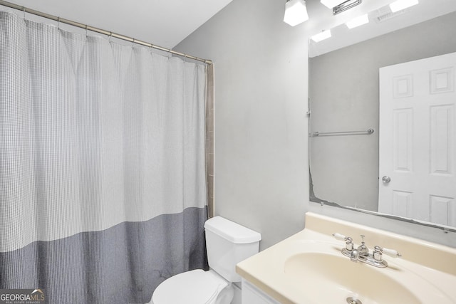 bathroom with curtained shower, toilet, and vanity