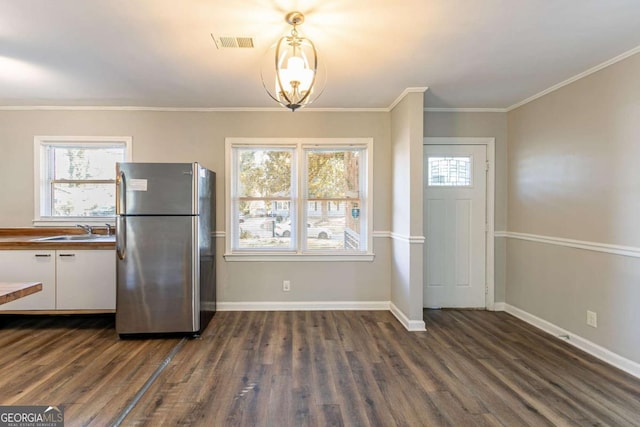 kitchen with sink, white cabinets, plenty of natural light, and stainless steel refrigerator