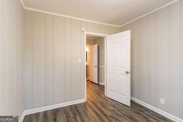 unfurnished room featuring ornamental molding and dark hardwood / wood-style flooring