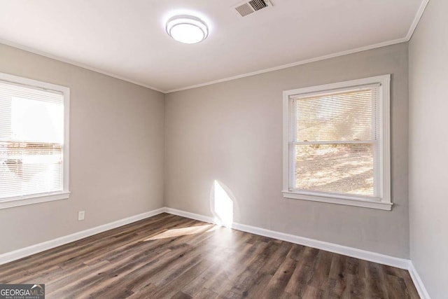 spare room with dark hardwood / wood-style floors and crown molding