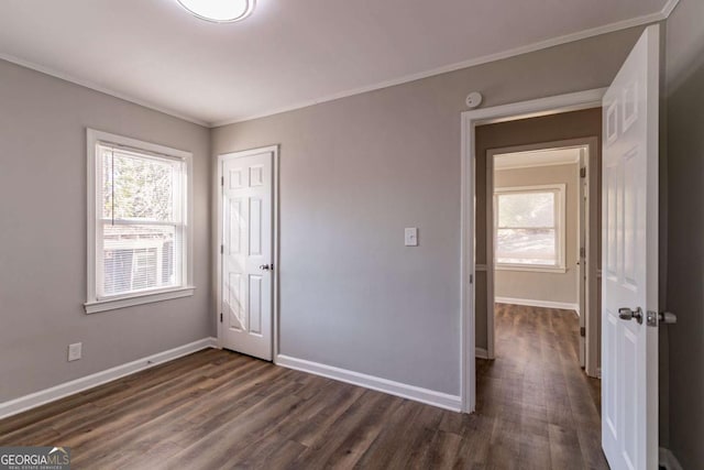 unfurnished bedroom featuring a closet, ornamental molding, and dark wood-type flooring