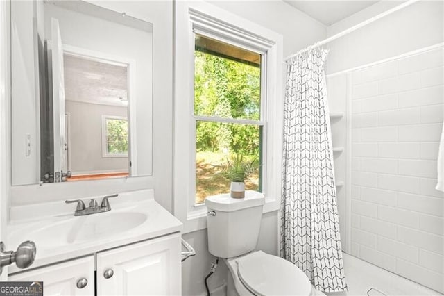 bathroom featuring toilet, walk in shower, and vanity