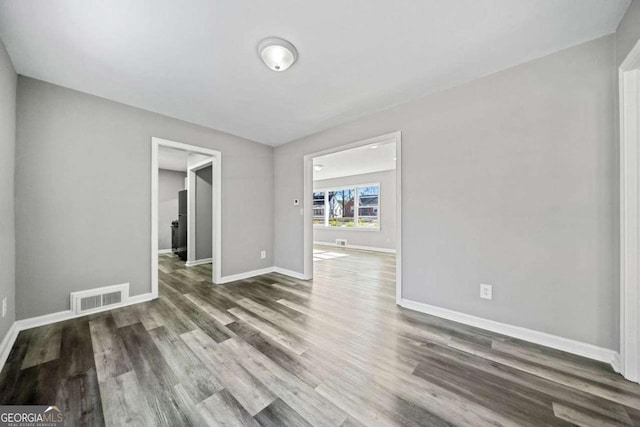 spare room with dark wood-type flooring