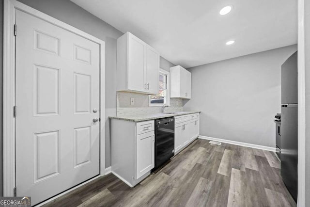 kitchen with dishwasher, white cabinetry, light stone countertops, and backsplash