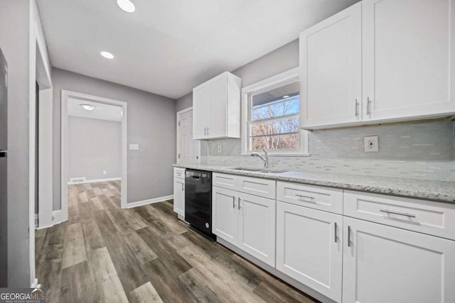kitchen featuring light stone countertops, tasteful backsplash, dishwasher, white cabinetry, and sink