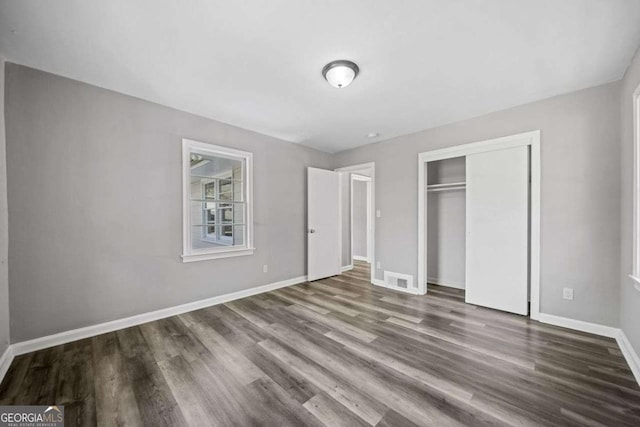 unfurnished bedroom with a closet and hardwood / wood-style floors