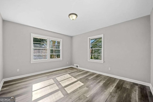 unfurnished room featuring a healthy amount of sunlight and hardwood / wood-style flooring
