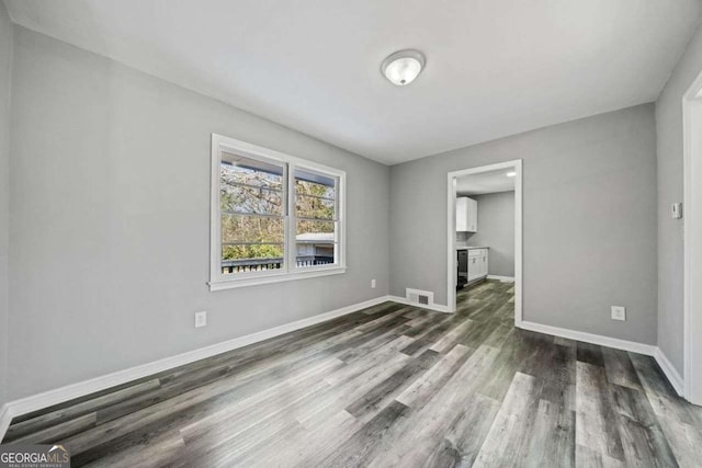 unfurnished room with dark hardwood / wood-style floors