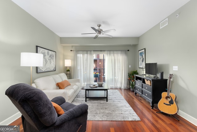 living room with ceiling fan and dark hardwood / wood-style flooring