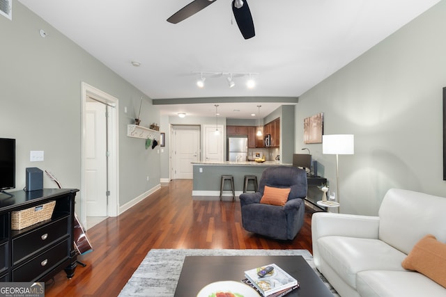 living room featuring ceiling fan and dark hardwood / wood-style floors