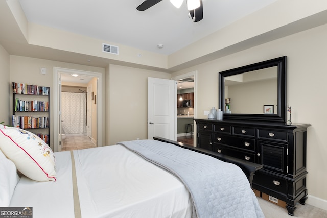 carpeted bedroom featuring ceiling fan and ensuite bath