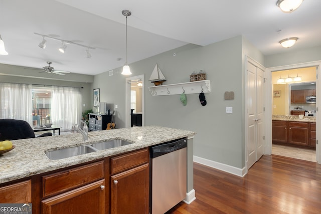 kitchen featuring light stone counters, sink, decorative light fixtures, and appliances with stainless steel finishes