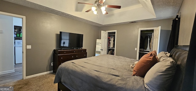 bedroom featuring ceiling fan, fridge, a tray ceiling, carpet floors, and a textured ceiling