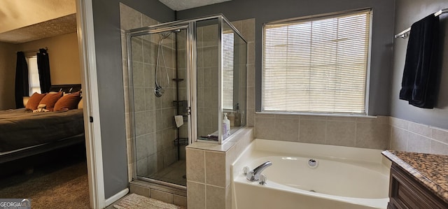 bathroom with plus walk in shower, vanity, and a textured ceiling