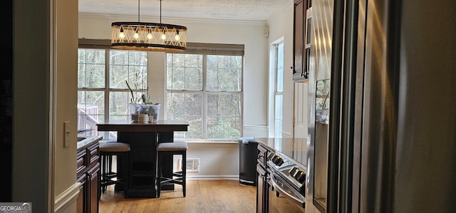 dining room featuring wood-type flooring, ornamental molding, a chandelier, and a textured ceiling