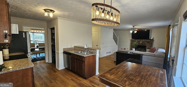 kitchen featuring a stone fireplace, dishwasher, dark hardwood / wood-style flooring, light stone countertops, and a textured ceiling