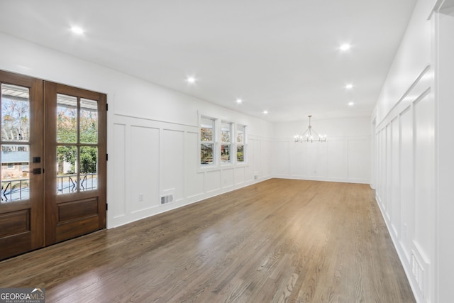 entryway with hardwood / wood-style flooring, an inviting chandelier, and french doors