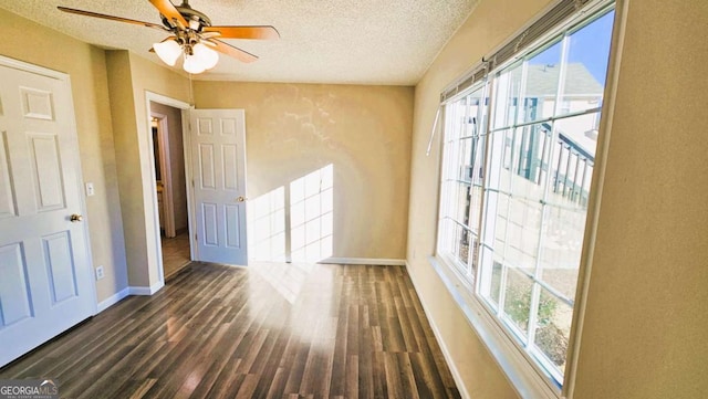 spare room with ceiling fan, dark wood-type flooring, and a textured ceiling