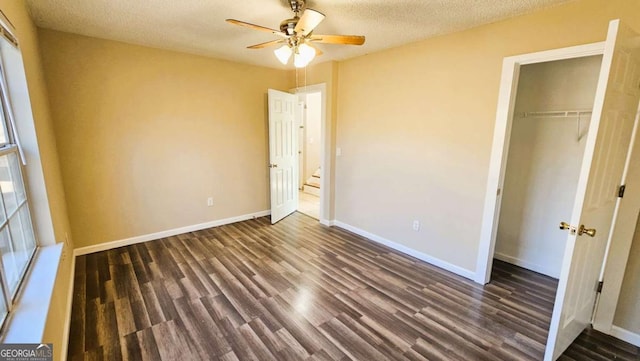 unfurnished bedroom featuring a closet, a textured ceiling, dark hardwood / wood-style floors, and ceiling fan