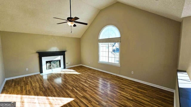 unfurnished living room with a textured ceiling, dark hardwood / wood-style floors, high vaulted ceiling, and ceiling fan