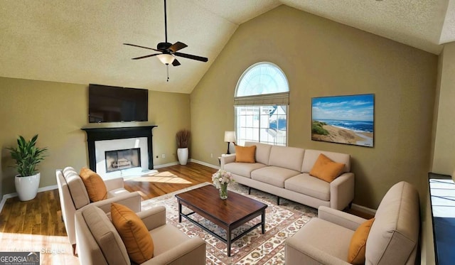 living room with ceiling fan, hardwood / wood-style floors, and lofted ceiling