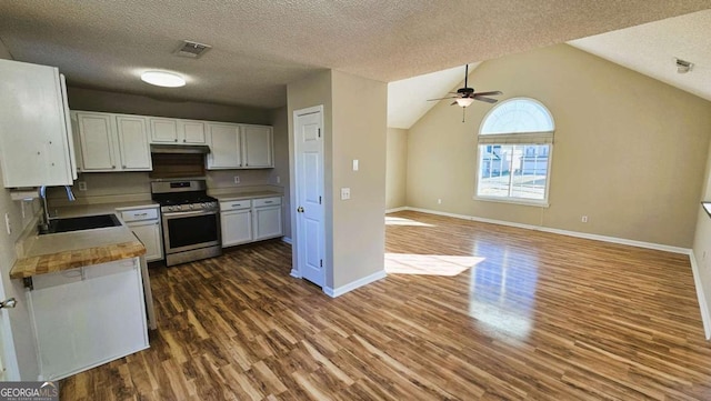 kitchen with dark hardwood / wood-style flooring, white cabinetry, stainless steel gas range, wood counters, and lofted ceiling